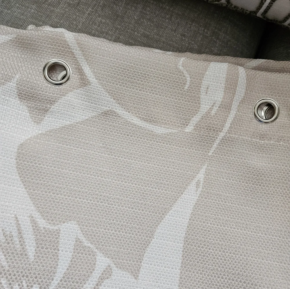 Floral tan and ivory fabric shower curtain with satin nickel hooks.
